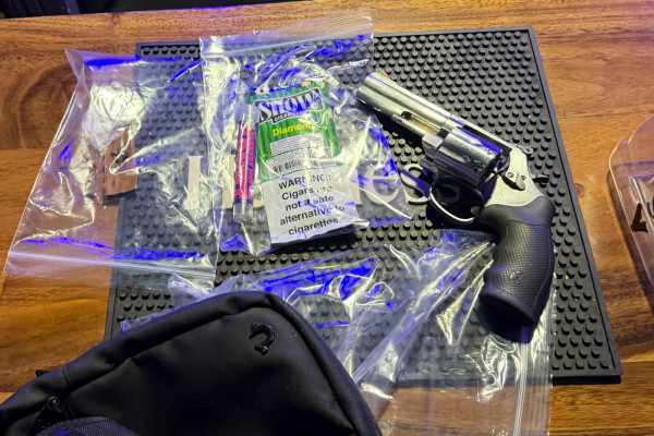 silver revolver on wood table with various drug paraphernalia 