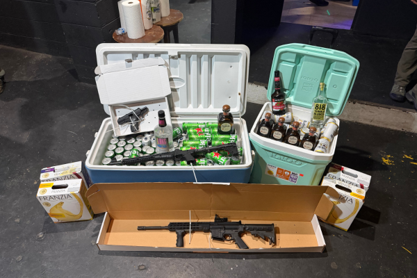 Two coolers filled with seized alcohol and three firearms