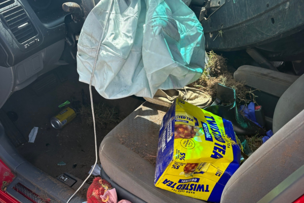 wrecked car interior with twisted tea box on drivers seat