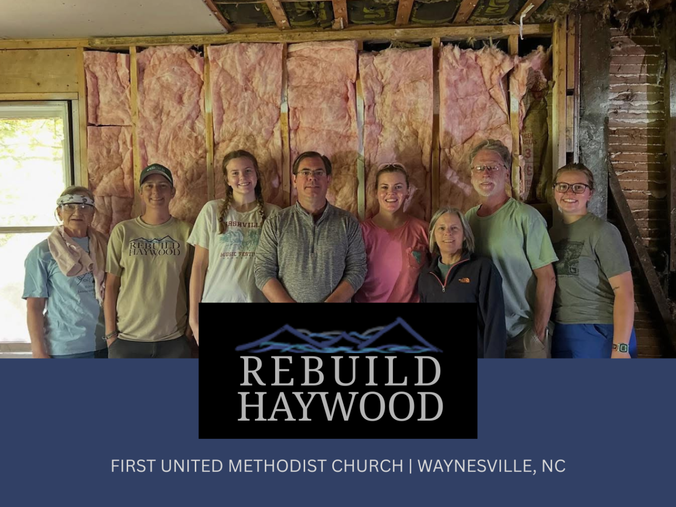 Volunteers stand in front of insulation recently installed in a home