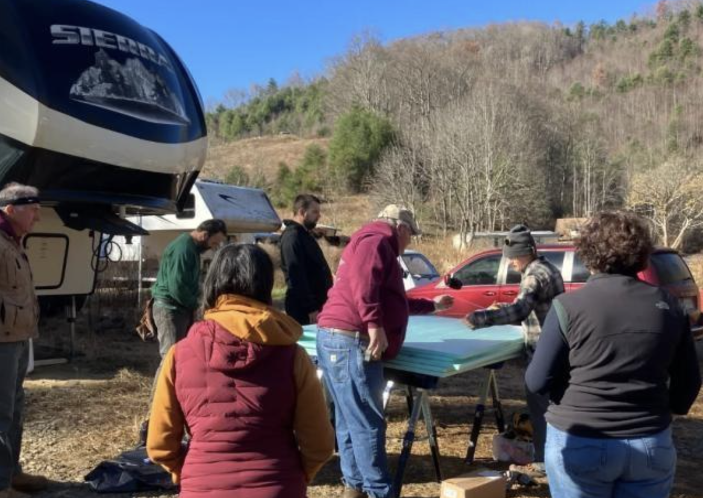 Volunteers add insulation to a travel trailer during the winter