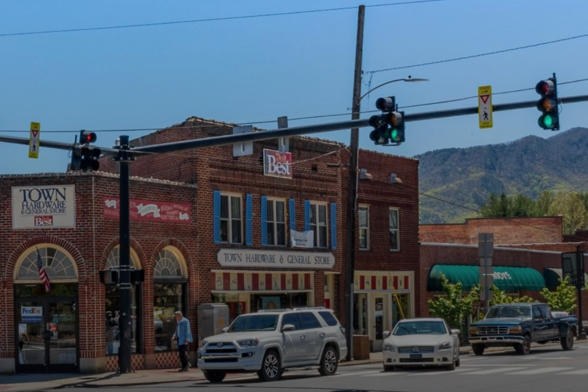 three vehicles stopped at a small downtown traffic light