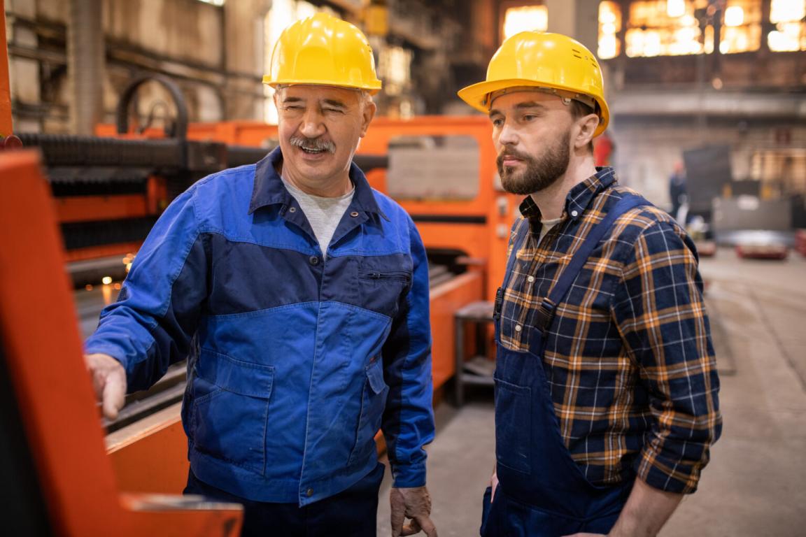Two men in hard hats meeting in a warehouse