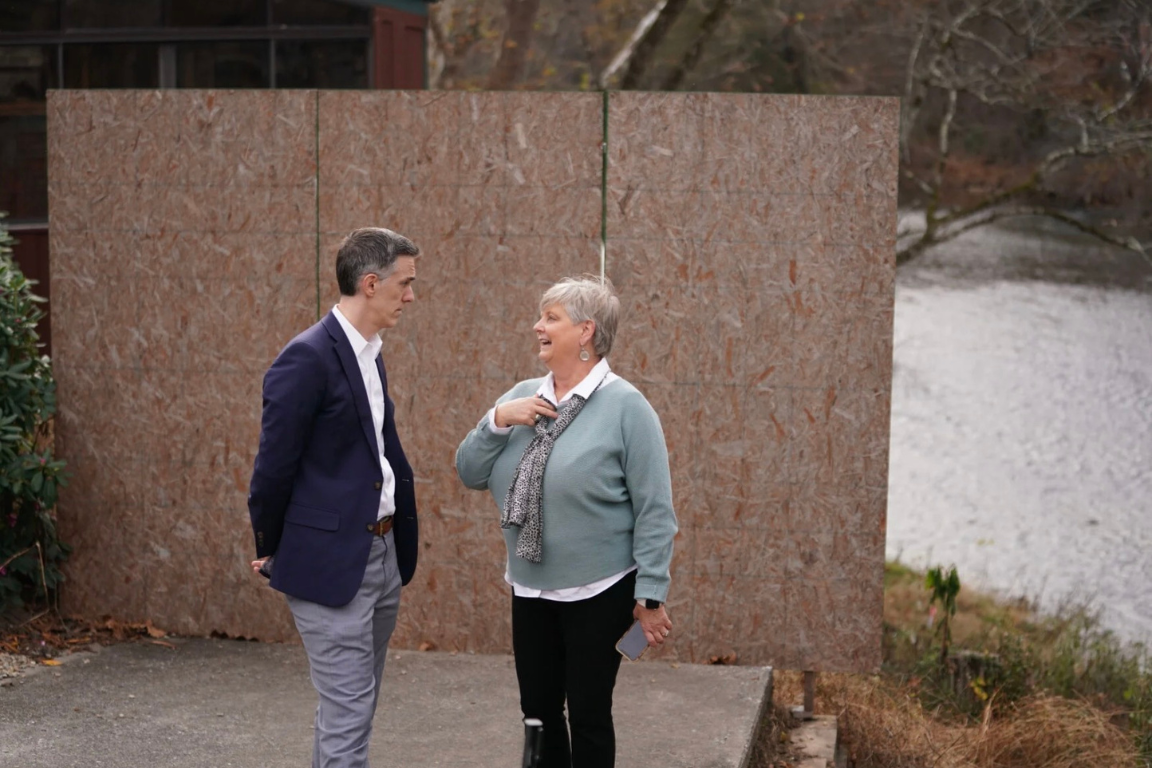 Two leaders engaged in conversation near a river