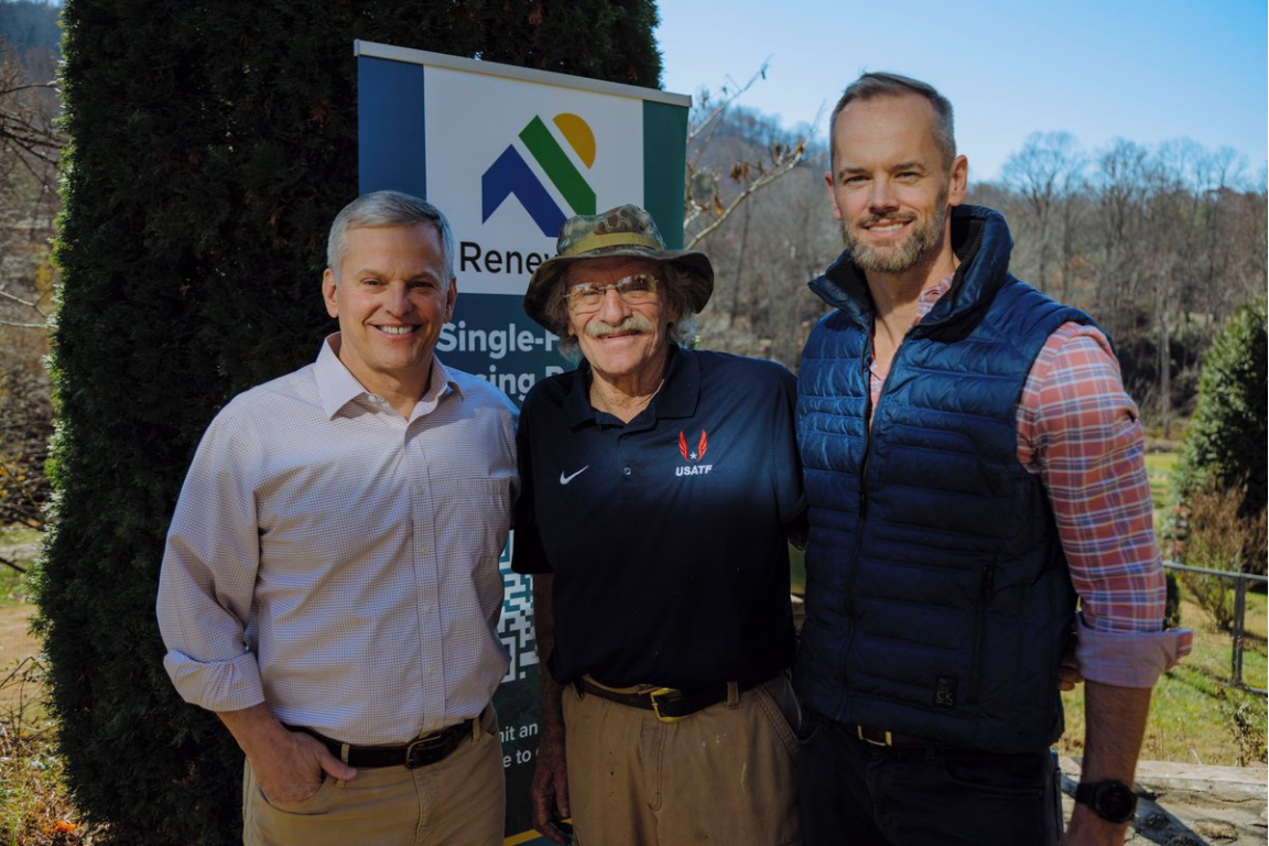 Three men standing outside at a home rebuilding site