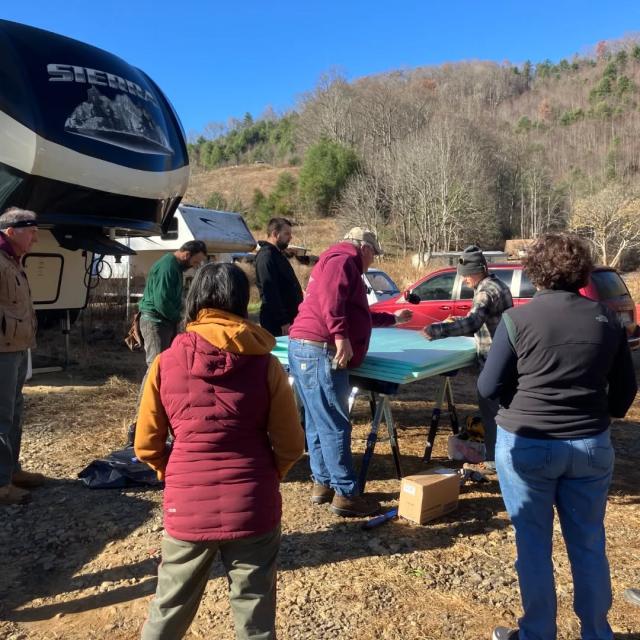 men and women performing maintenance on a trailer