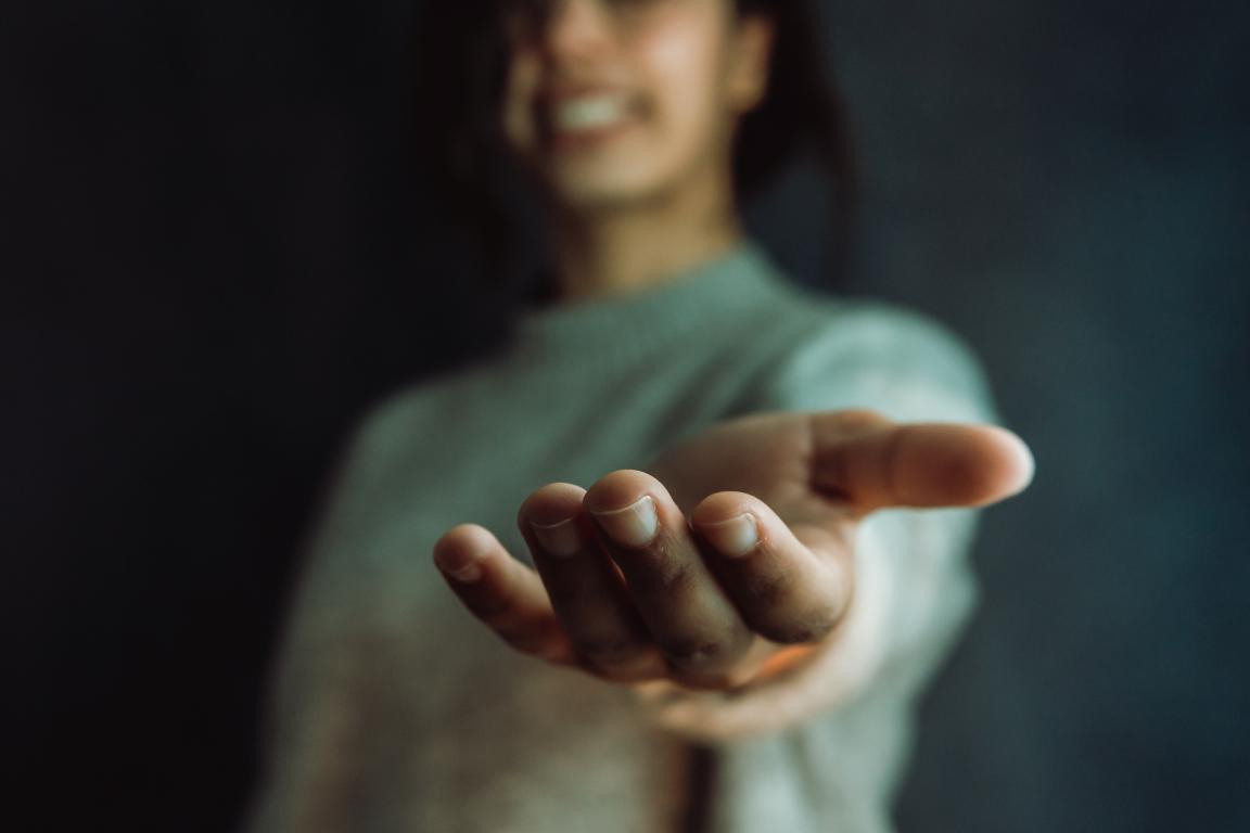 woman holding out her hand in a shallow depth of field.