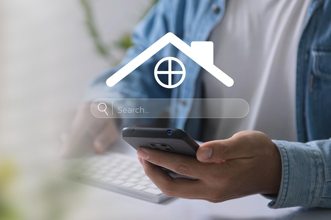 Someone holding a cell phone with a home icon and search box above the phone.