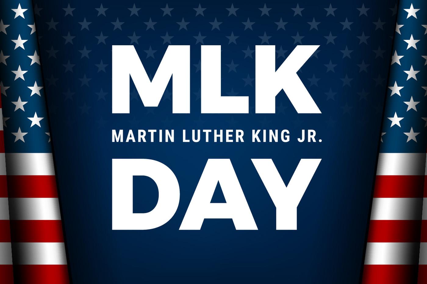 Martin Luther King Jr. Day banner with white letters on dark blue background, and the American flag on each side.