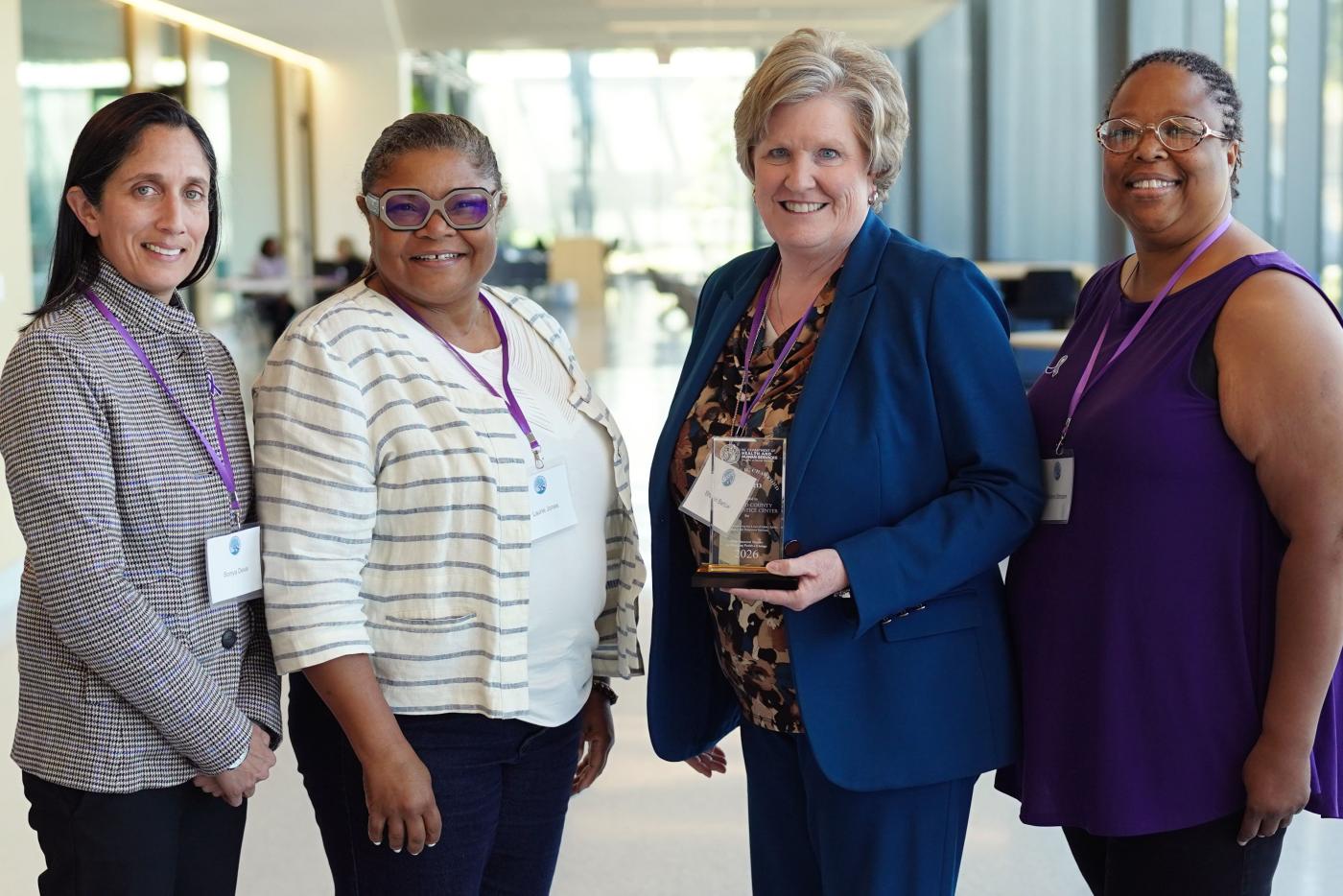 Four members of the Family Justice Center Elder Justice Committee holding their recent glass award