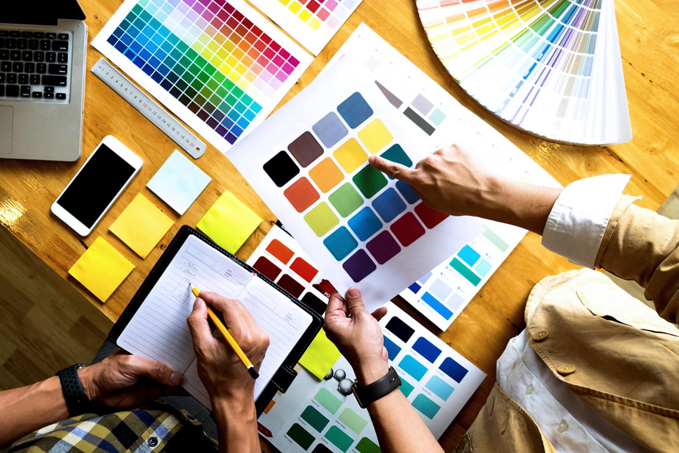 Graphic designers choose colors from the color swatch samples for design.