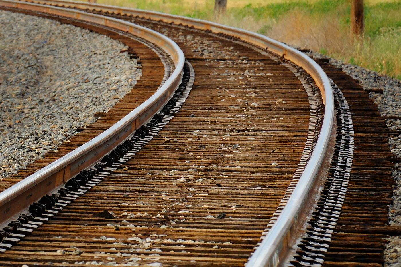 Curved railroad tracks in a rural setting.