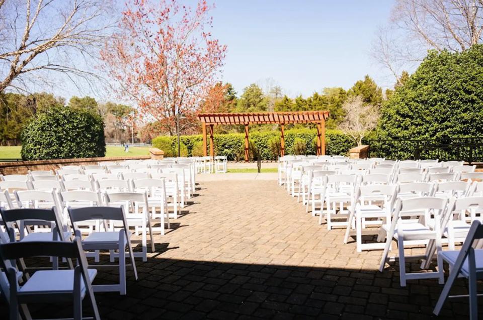 The large terrace at Bur-Mil Park Event Center on a sunny day with a large number of white folding chairs set up for an event.
