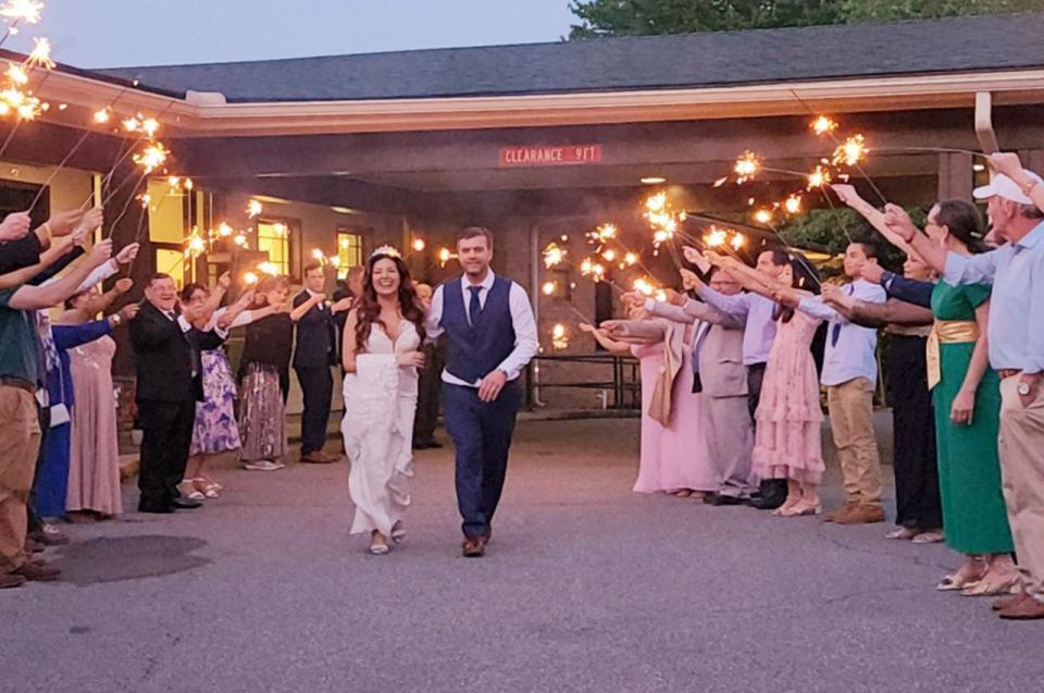 A bride and groom proceeding out with people on both sides at the Portico at Bur-Mil Park Events Center.