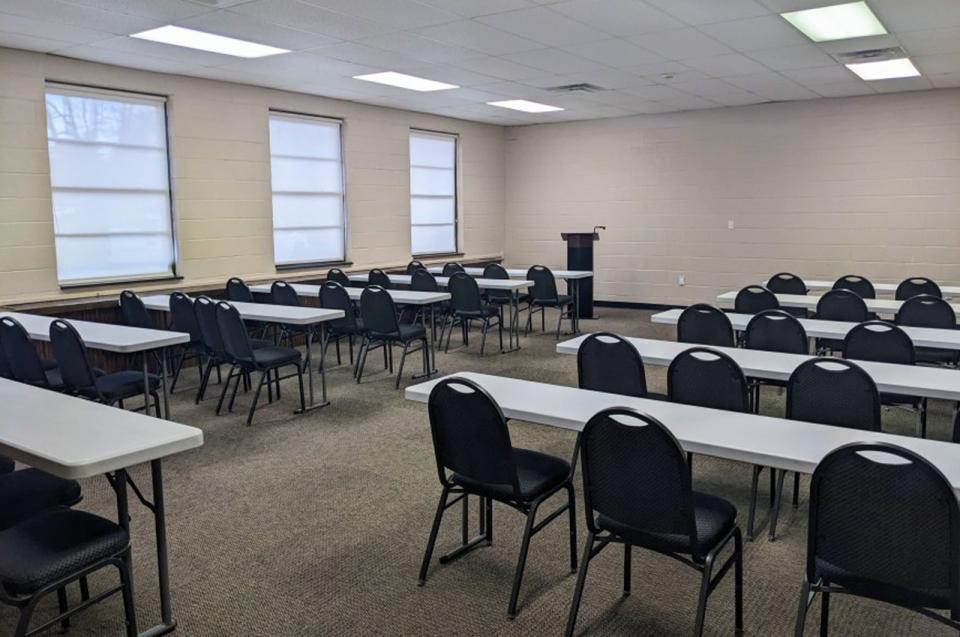The Training Room at the Bur-Mil Park Event Center with long tables with chairs for classroom-like seating and a podium for speaker.
