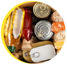 Overhead view of canned and dry food goods in a cardboard box.