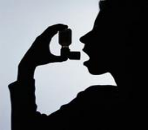 Silhouette of a person using an asthma inhaler