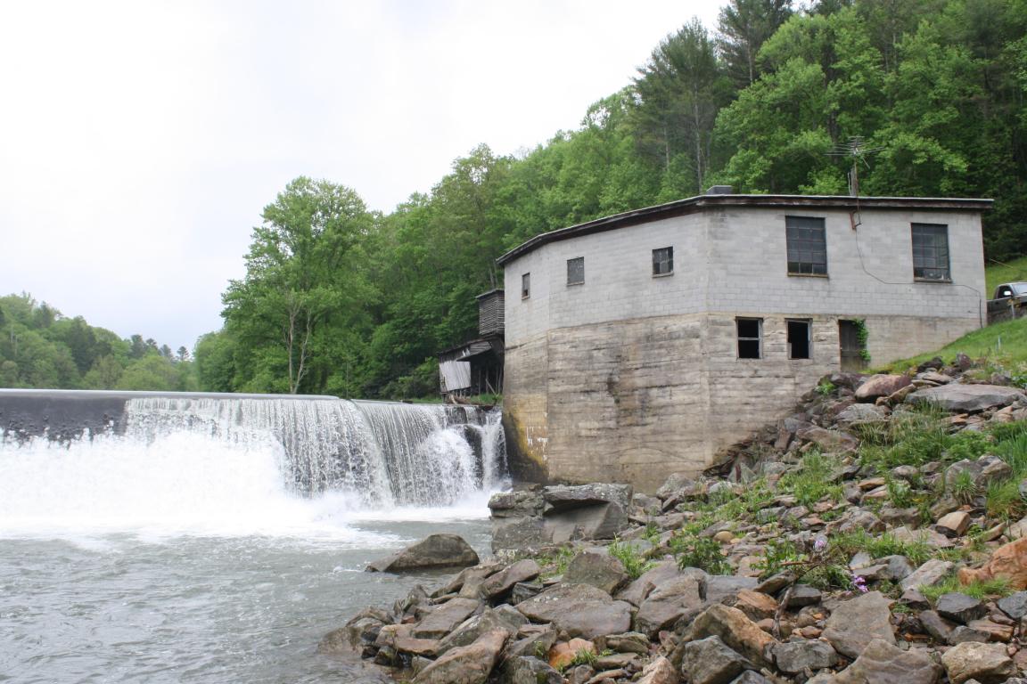 View of Ward Mill Powerhouse with water flowing over dam.