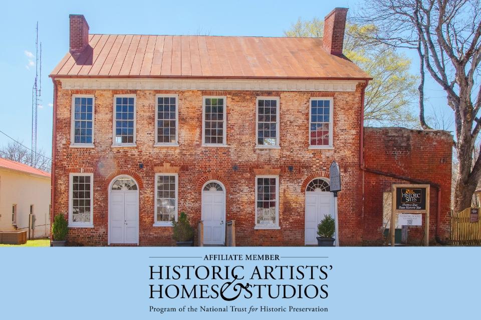 A two story brick building with a logo for the Historic Artists Homes and Studios logo on the bottom over a light blue box