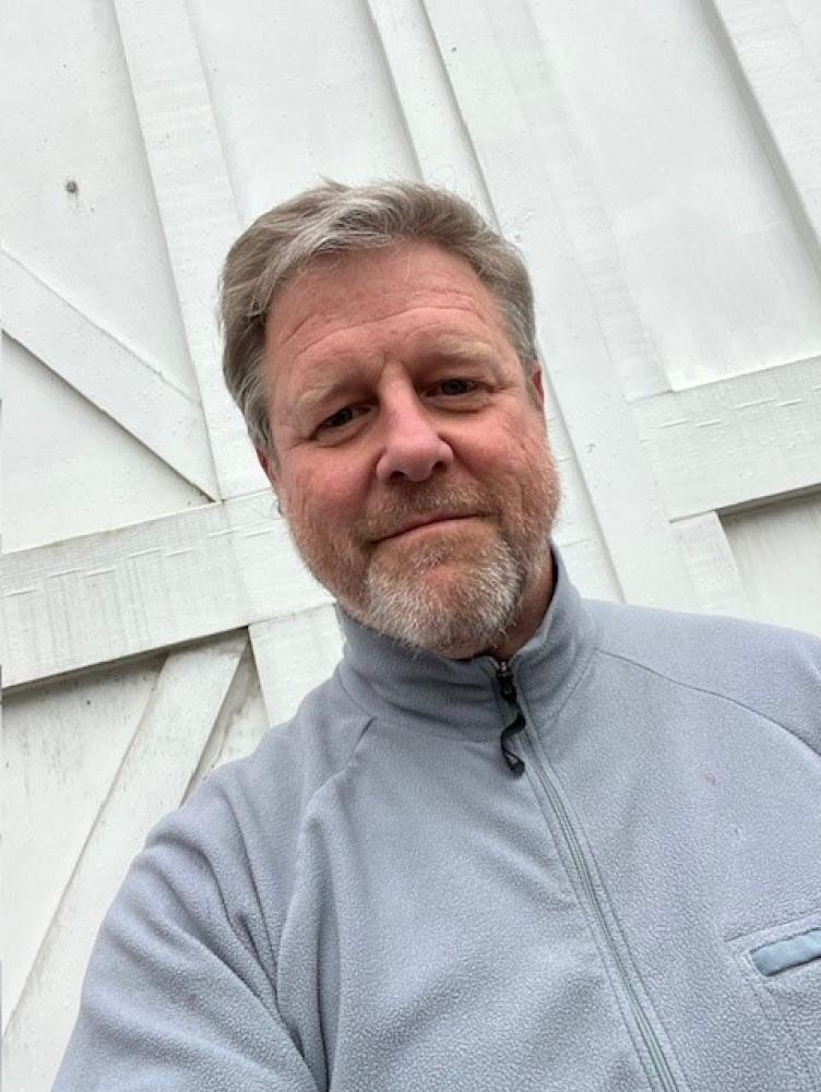 Man standing in front of white wooden background
