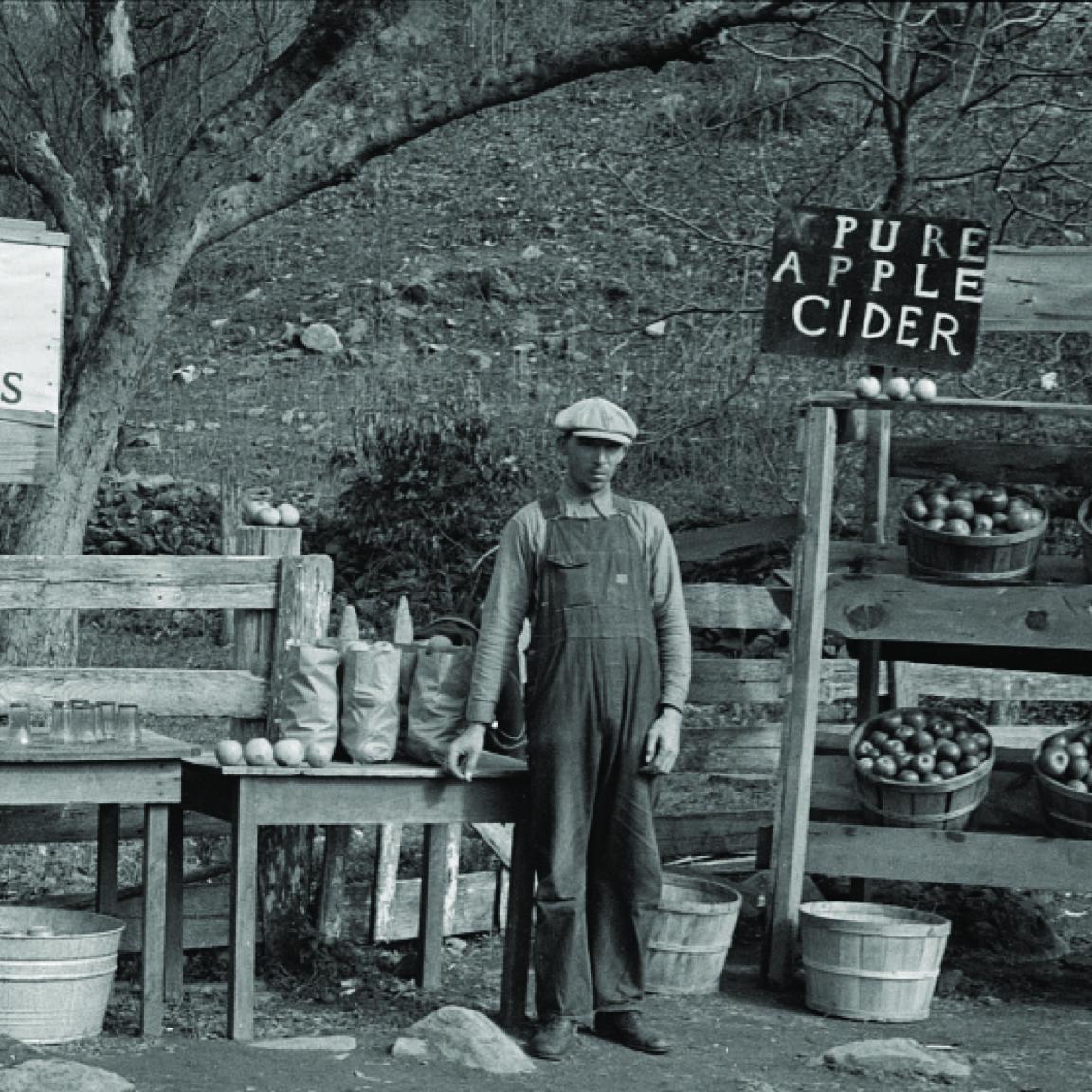 Vintage photograph of a man selling apples by the road