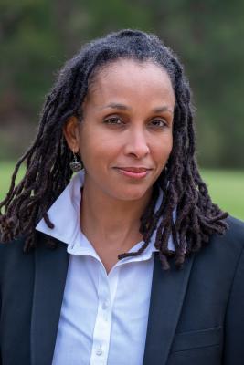 portrait of an African American woman in a blue shirt and black jacket