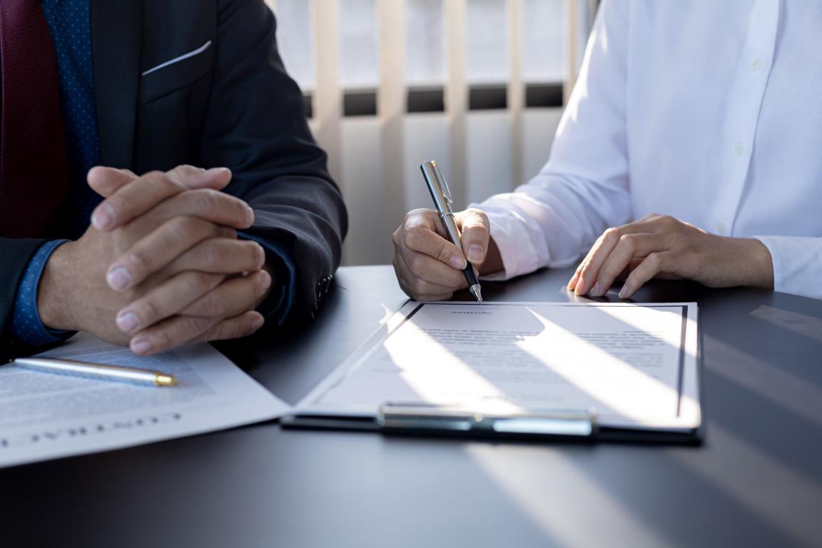 two people reviewing and signing paperwork