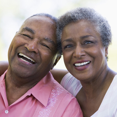A senior man and woman appear to be happy and laughing close together.