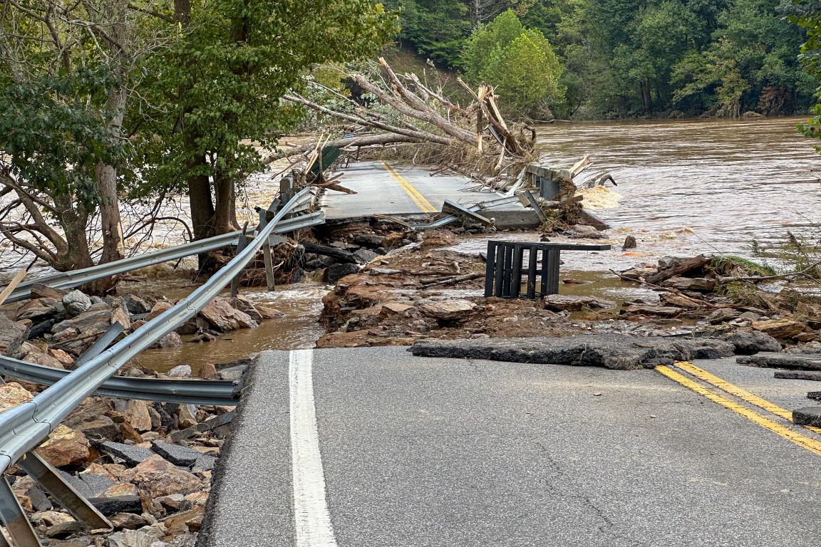 Broken road with overflowing water from storm.