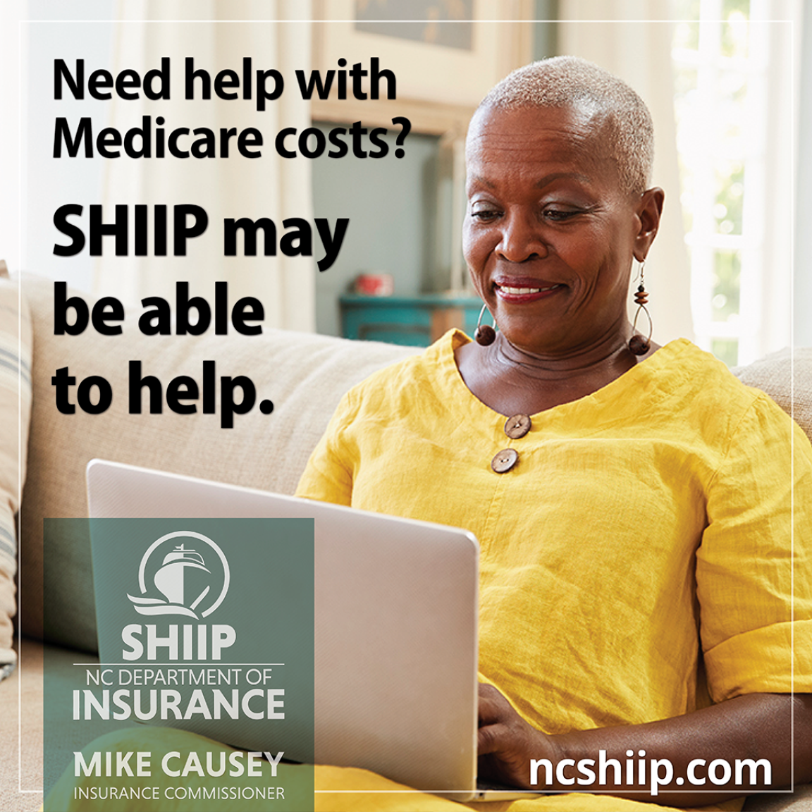 Woman in bright yellow dress types on laptop on the couch.