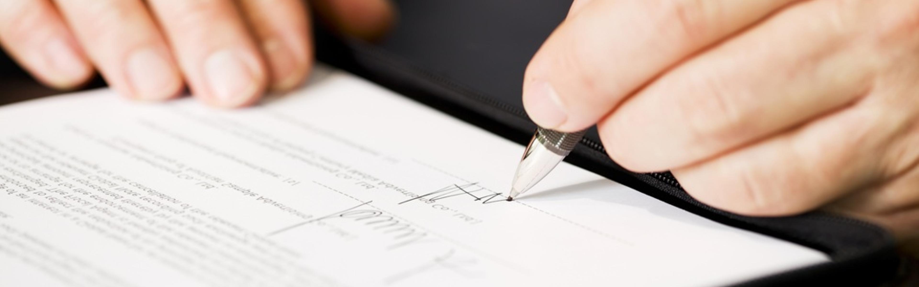 Hands signing an agreement