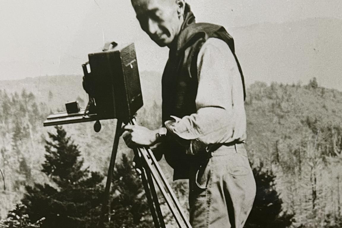George Masa holding a camera on a mountainside
