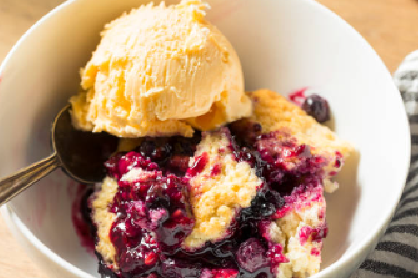 Blackberry dumpling pie with ice cream in a bowl