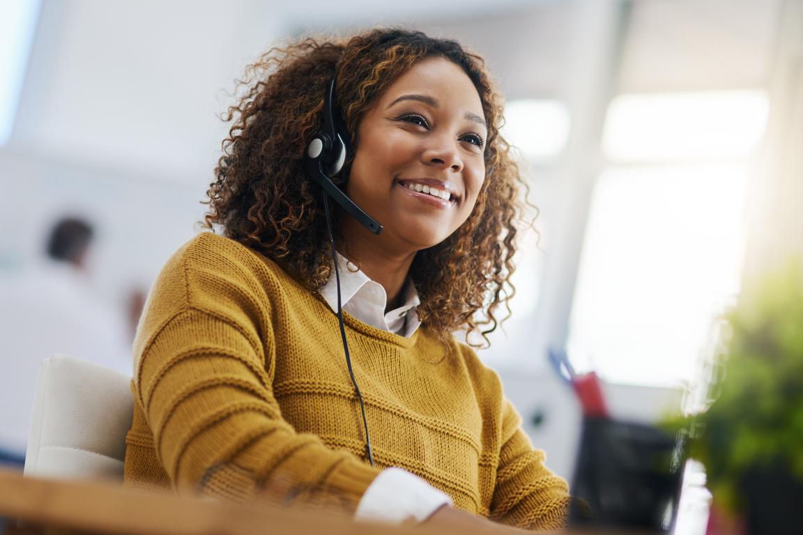 woman answering the phone on a headset in an office environment
