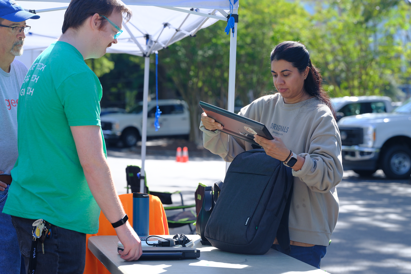 Woman donates a laptop at Digital Drive 2025 with Kramden Institute and NC TECH