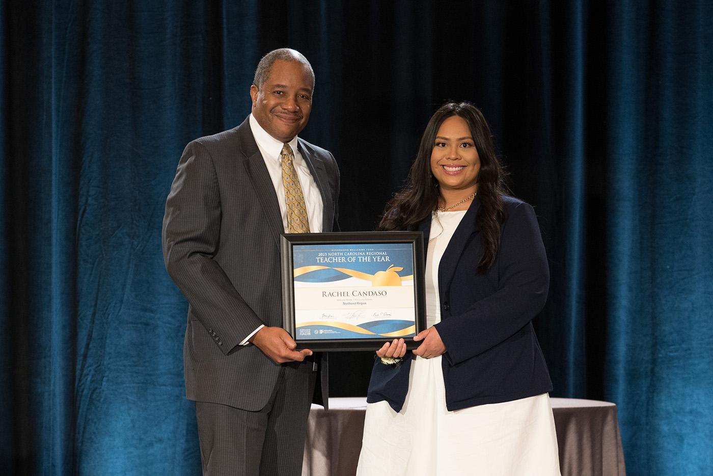 NC Teacher of the Year Rachel Candaso accepts her award from State Superintendent Mo Green on a stage.