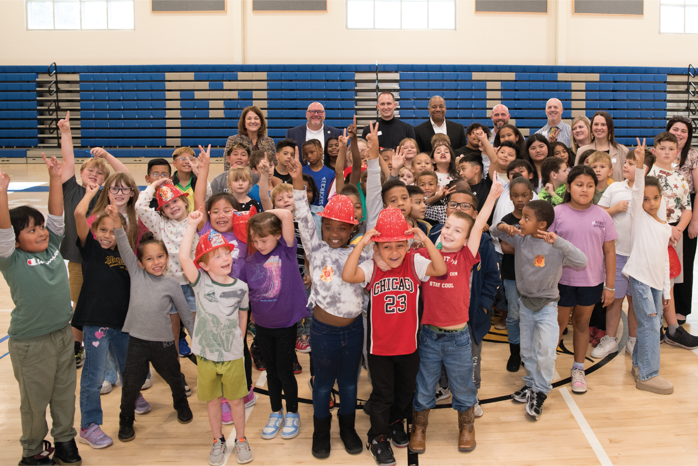  A group of smiling students and staff pose for a photo in the Mountain View Elementary School gym.