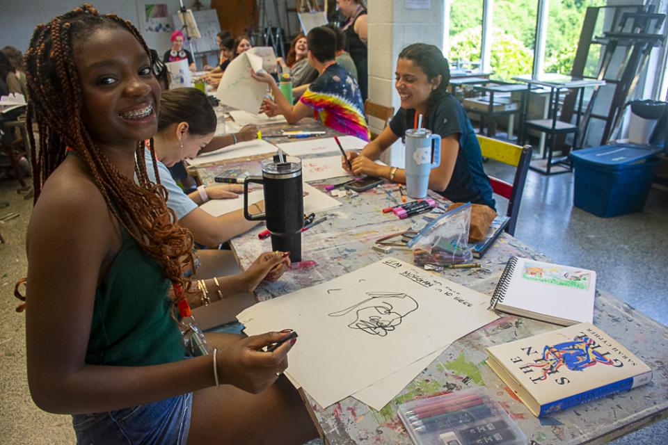 Governor's School student in visual art class smiles with a drawing