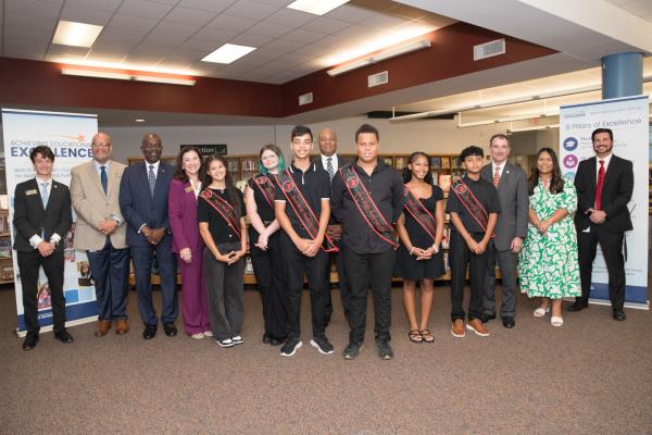 Superintendent Green stands with a group of students and school leaders at the launch event.