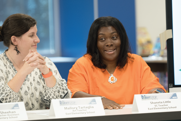  Little, wearing an orange shirt, speaks during a panel discussion.