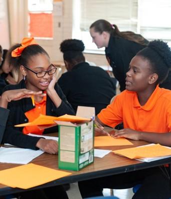 Two students doing schoolwork at a large table.