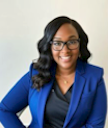 Picture of a woman in glasses wearing a professional jacket and shirt