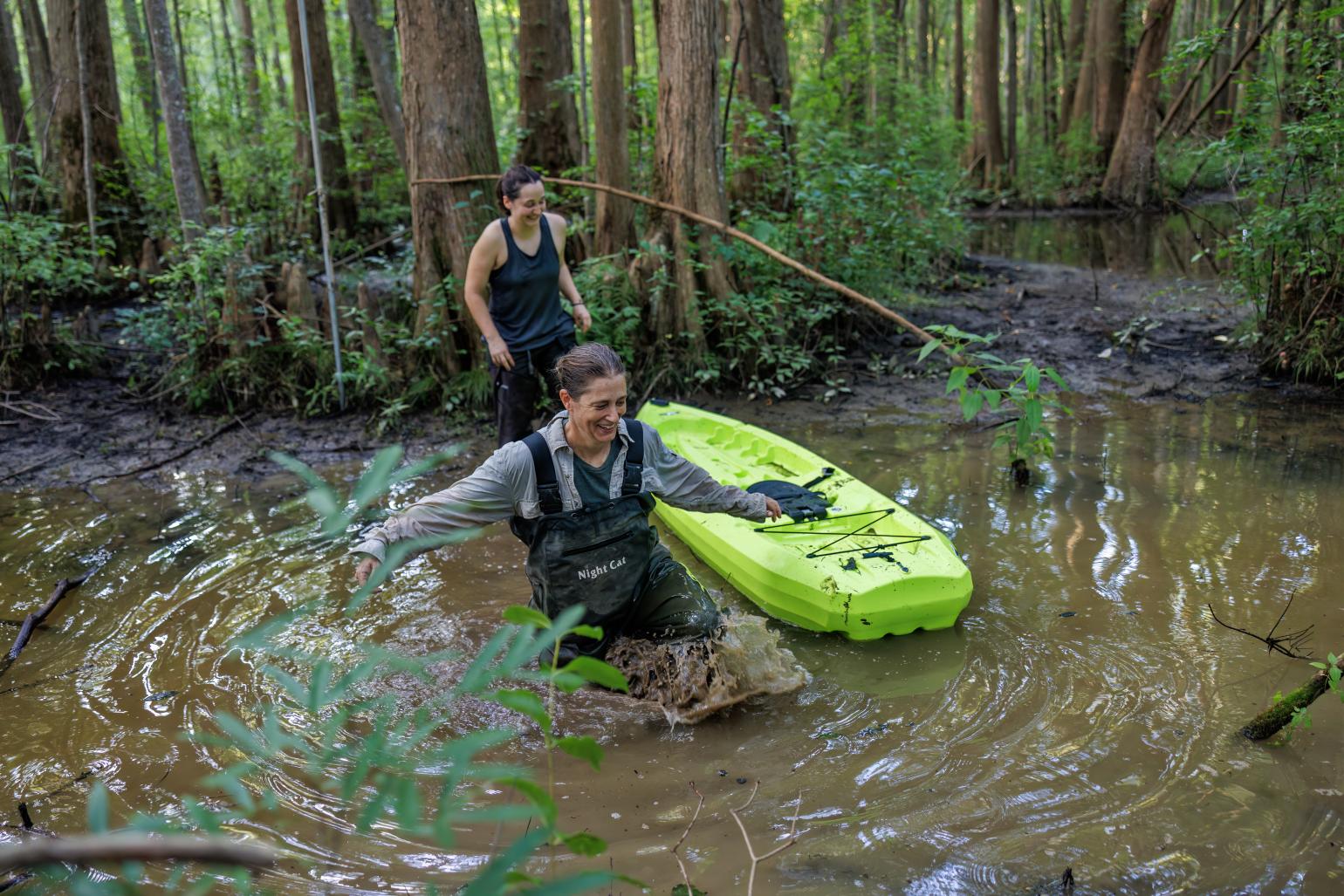 Two NC Wildlife biologists in swamp with kayak