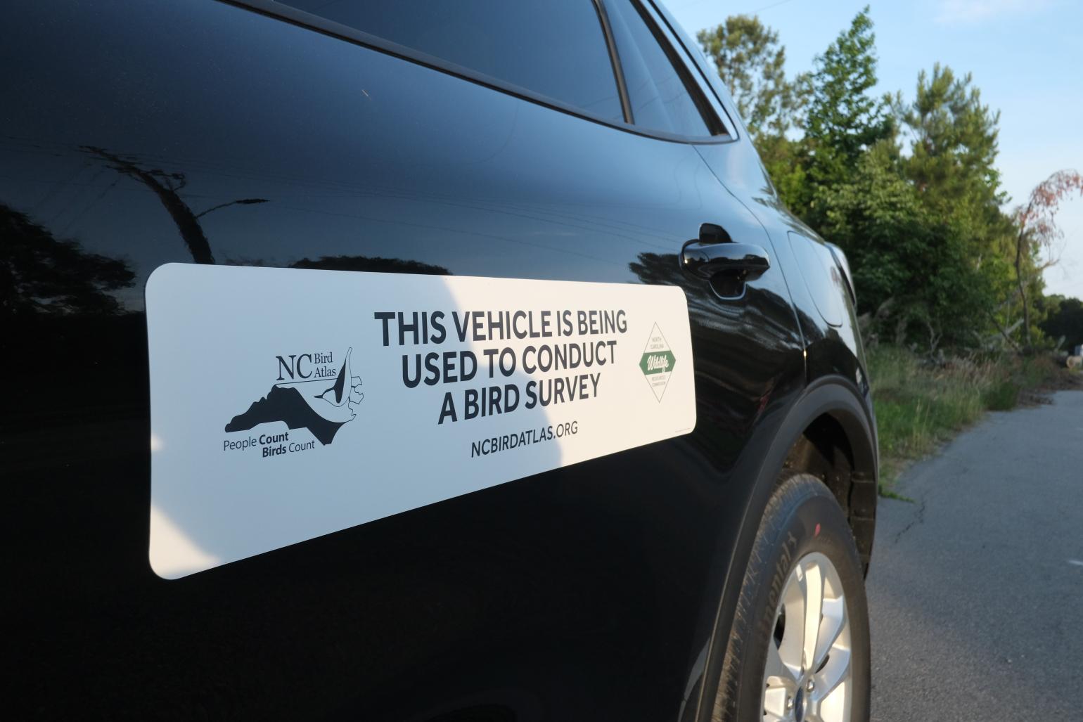 A magnet on the side of a vehicle that reads "this vehicle is being used to conduct a bird survey" with the NC Bird Atlas logo and NCWRC logo