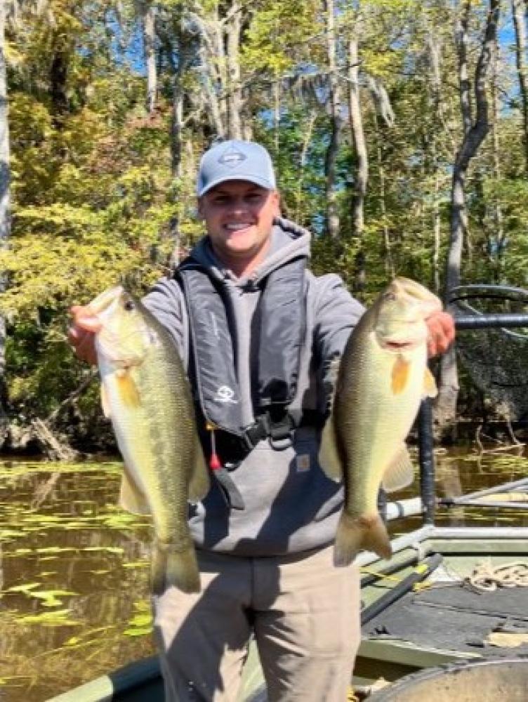 Biologists holding two largemouth bass