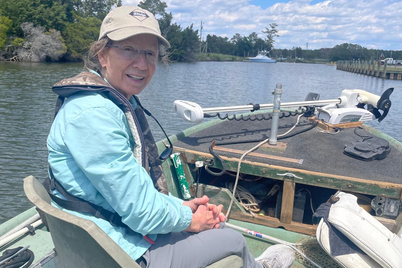 Kelly Davis sits in a boat under blue skies