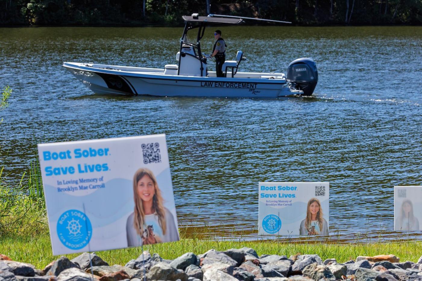 a patrol boat in the water in the background with boating safety signs in the foreground