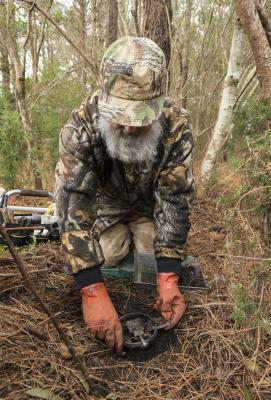 Man sets a trap in the woods