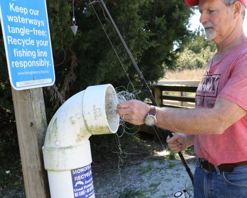 A man deposits netting in a Keep Our Waterways Tangle-free receptacle