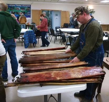 NC fur dealer Kevin Myers inspects otter pelts at the Marshall Fur Sale